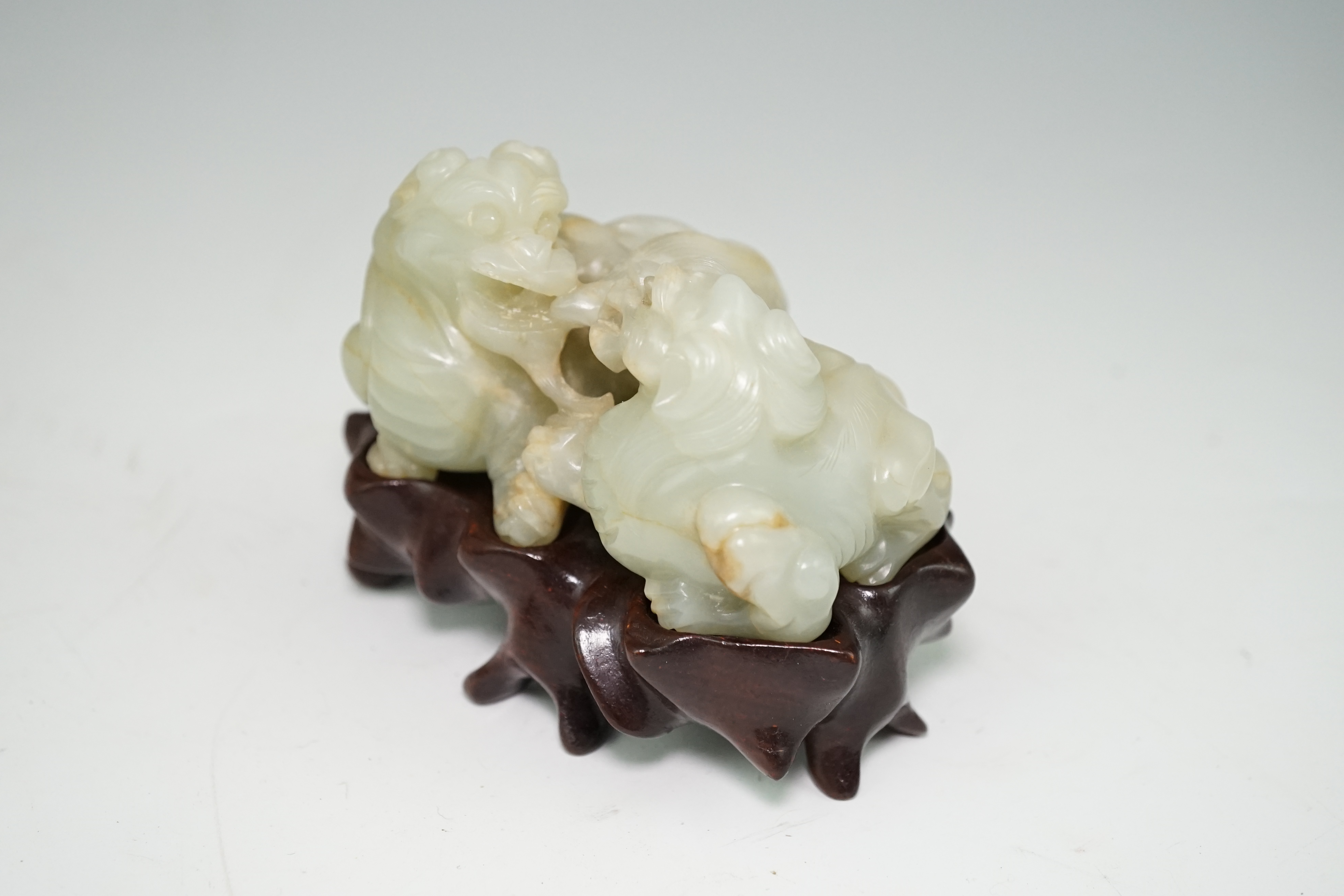 A Chinese celadon and russet jade group of two lion-dogs, 19th century